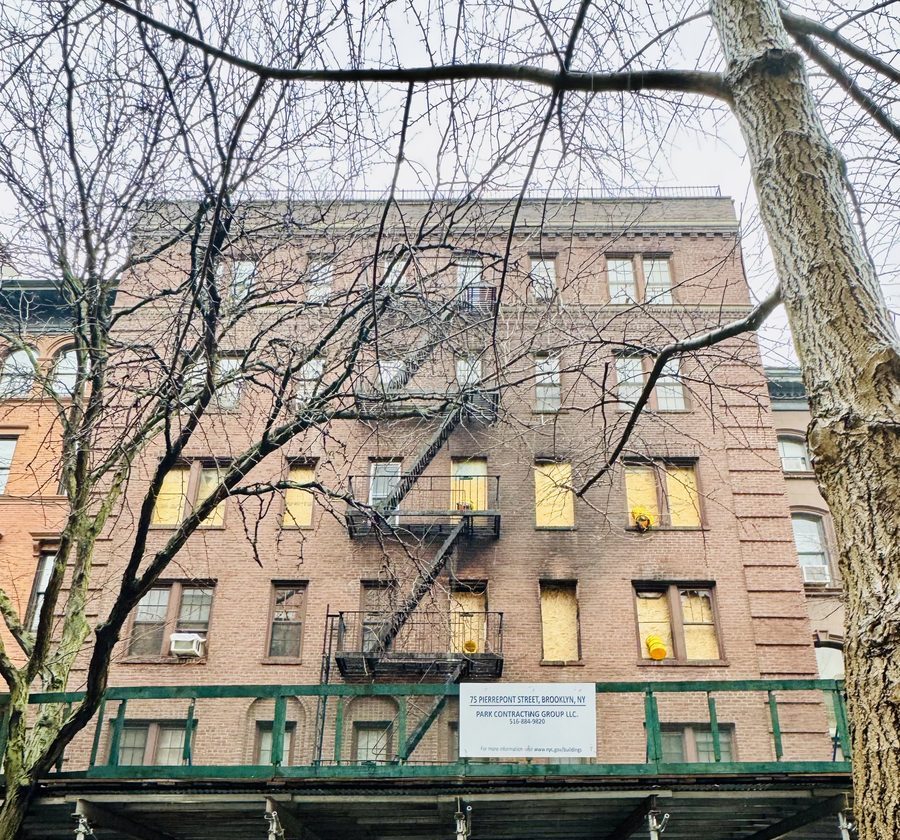 75 Pierrepont Street with scaffolding and plywood over fire-damaged windows